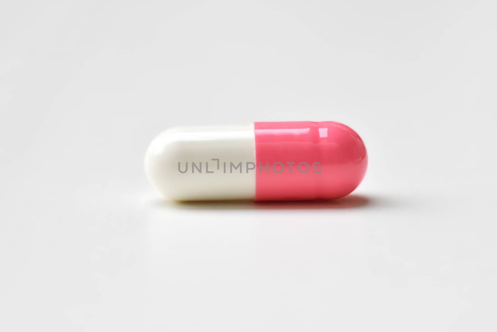 Pharmaceutical medicine pills, tablets and capsules pink-white on white background. Flat lay. Copy space. Medicine concepts. protect colona virus or covid 19. Cure infection. Selected focus