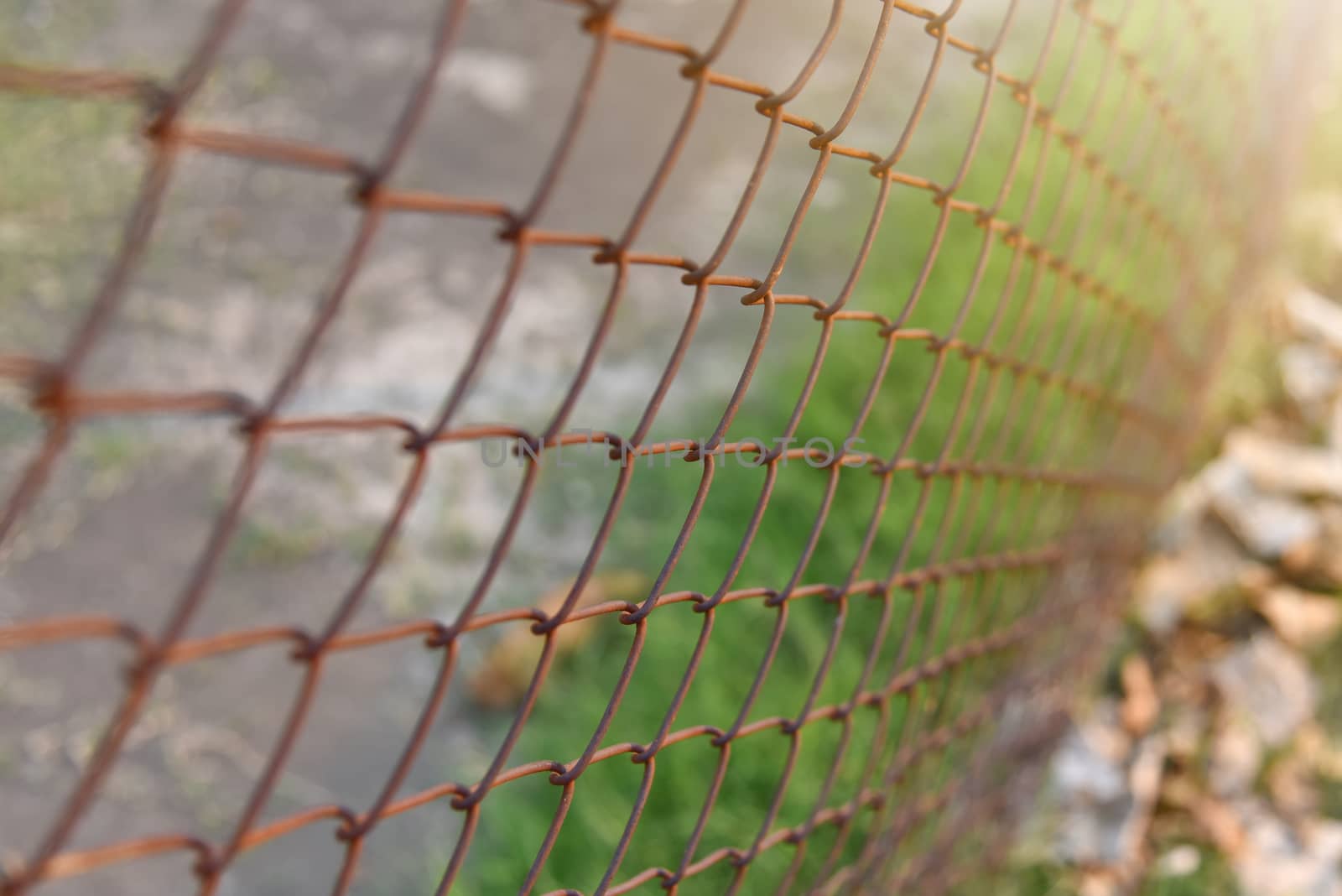 Beautiful view of Background texture of old rusty wire mesh. Cut off picture, horizontal, place for text, no people. Conception of construction and safety at sunset. Selected focus