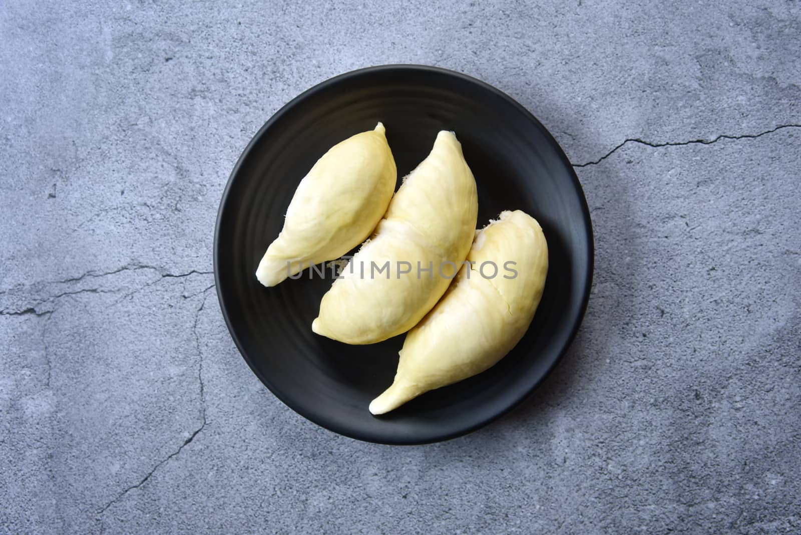 Top view Durian riped. King of Fruits. Durian is a popular tropical fruit in Thailand. Betel of durian on black dish on Dark color background. Seasonal fruit concept. Selected focus.
