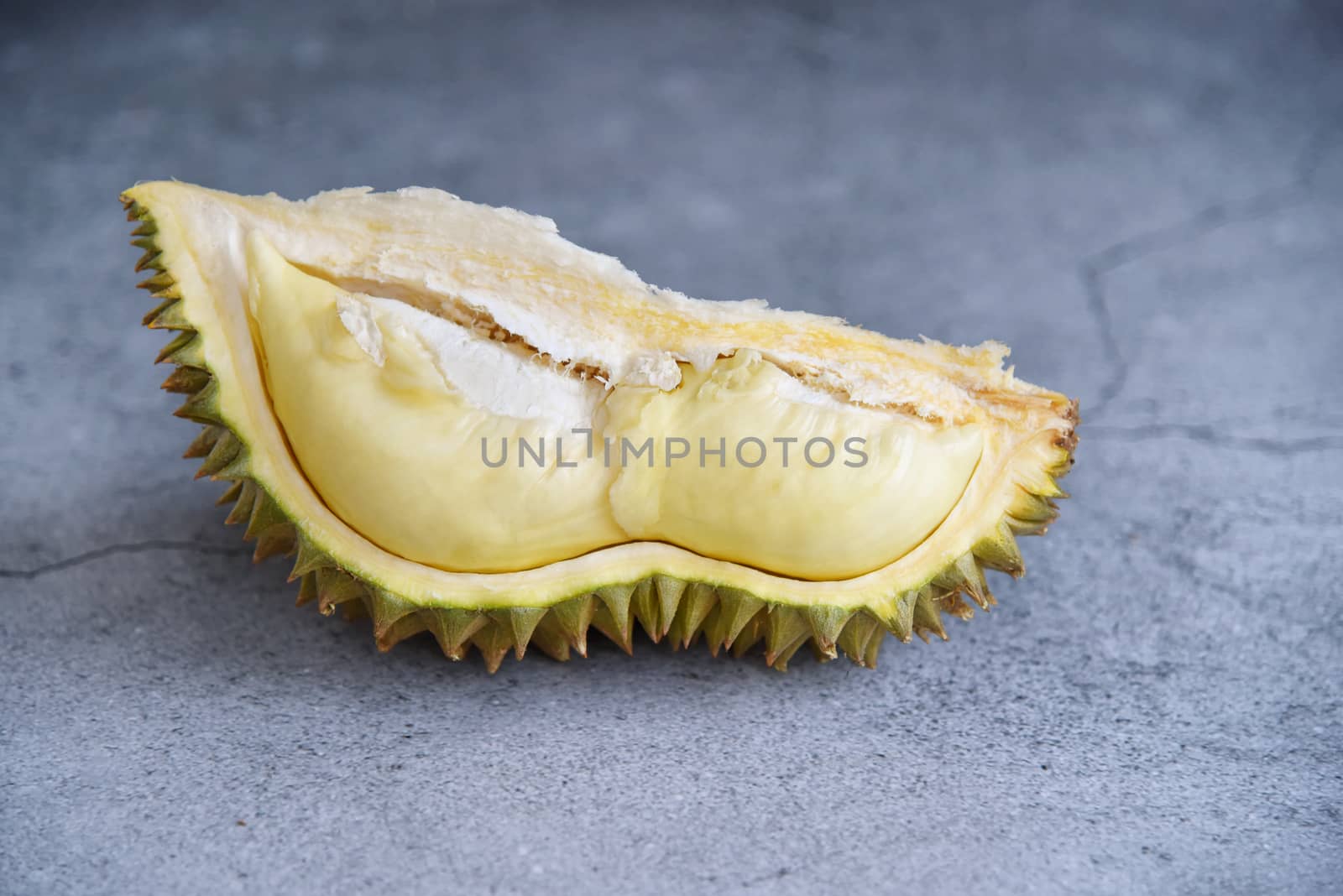 Durian riped. King of Fruits. Durian is a popular tropical fruit in Thailand. Betel of durian with durian peel on Dark color background. Seasonal fruit concept. Selected focus.