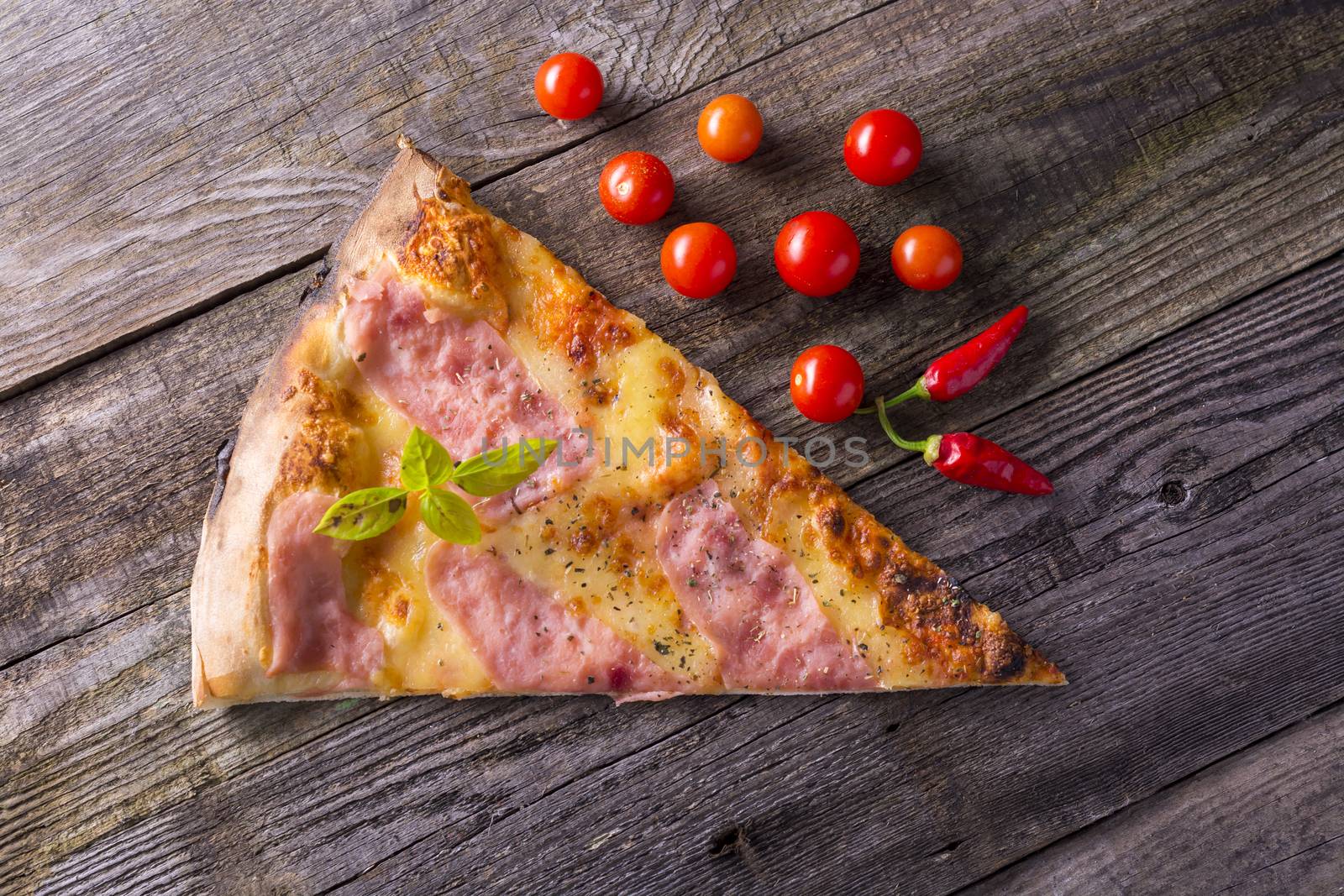 Pizza on wooden table, cherry tomato and hot peppers by adamr