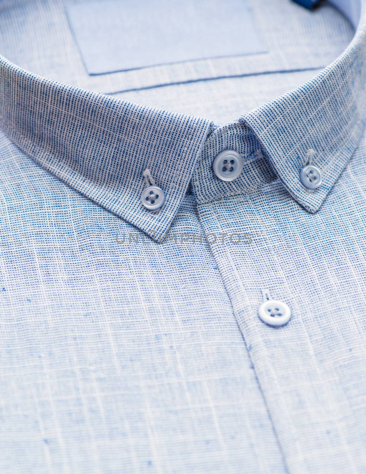 blue shirt with focus on collar and button, close-up