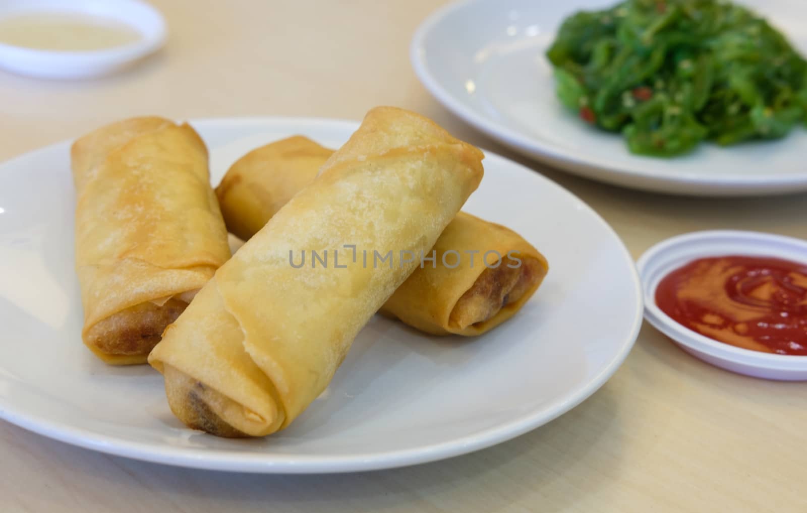 Fried Chinese Traditional Spring rolls food, serving dish and seaweed salad, selective focus
