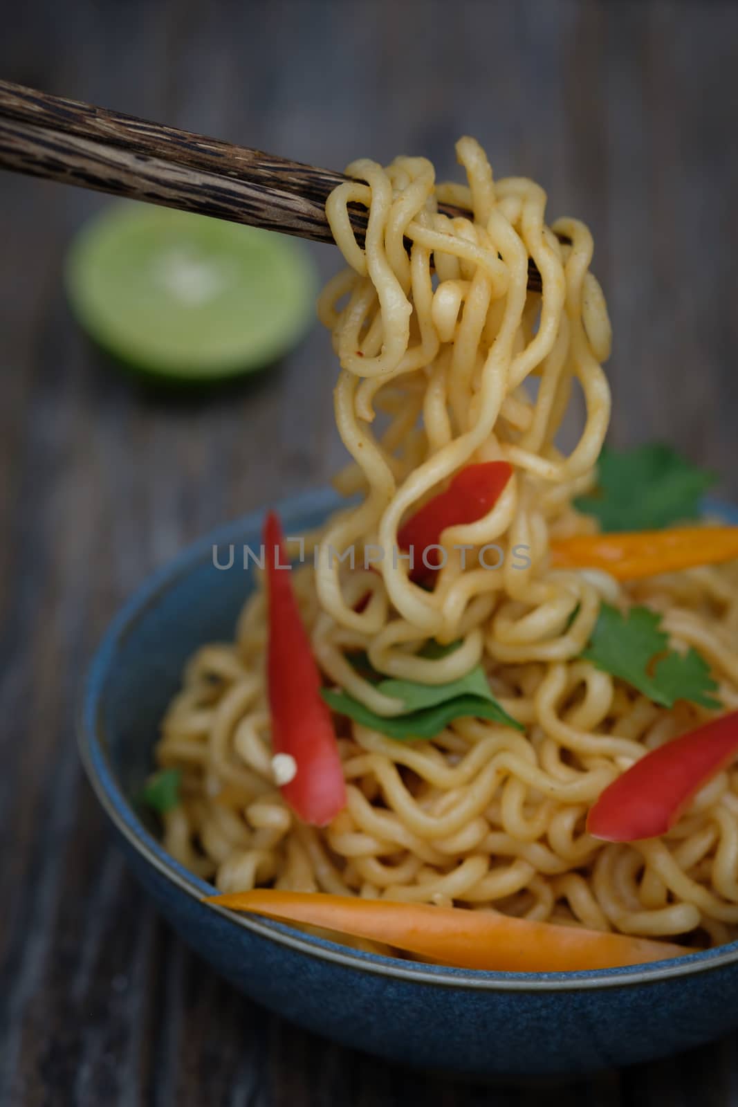 Still life instant noodles with sliced bell pepper on chopstick, junk food or fast food concept.