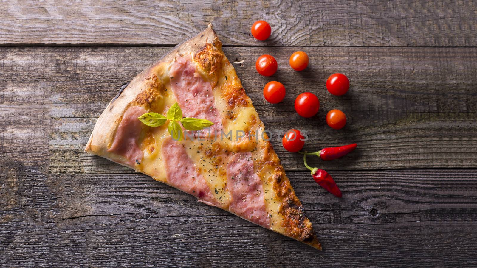 Italian food - pizza on wooden table. Cherry tomato and hot peppers