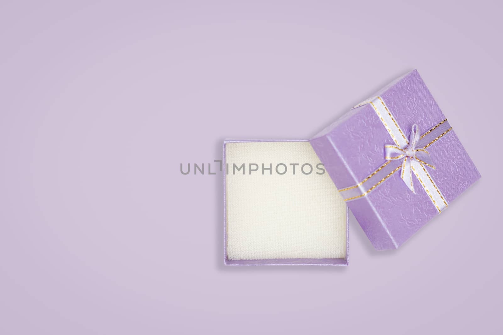 Top view of opened purple gift box on purple background. with copy space for text.