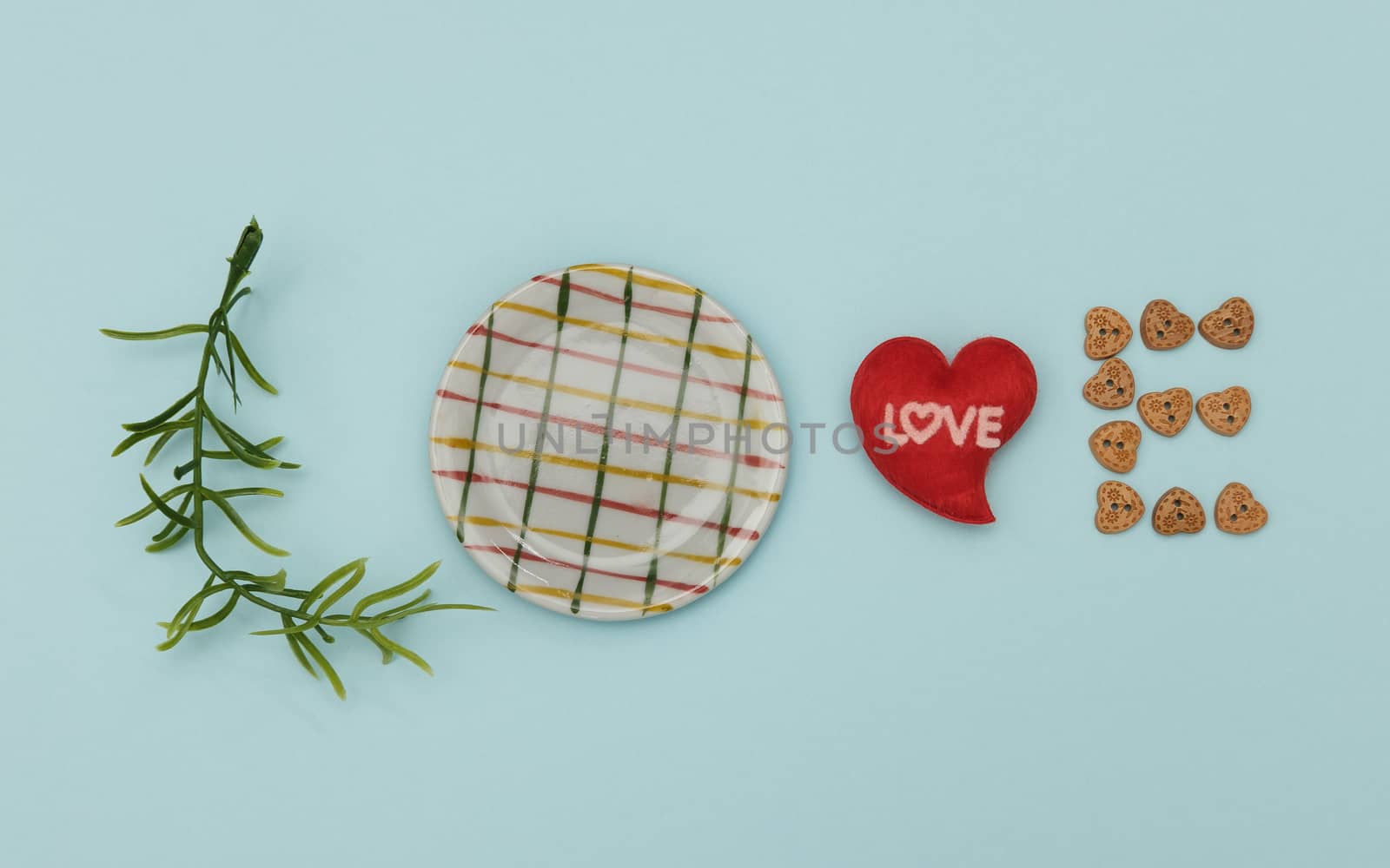 Words of love from leaves, dish, mini heart shape and wooden button on blue background, Valentine concept.