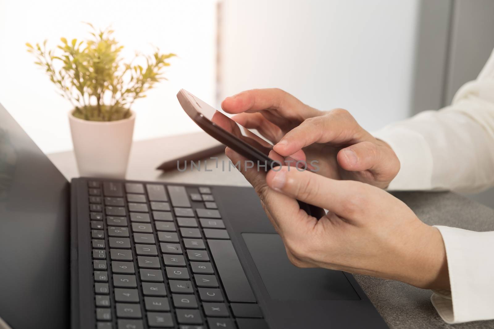 businessman using smartphone and laptop in office.