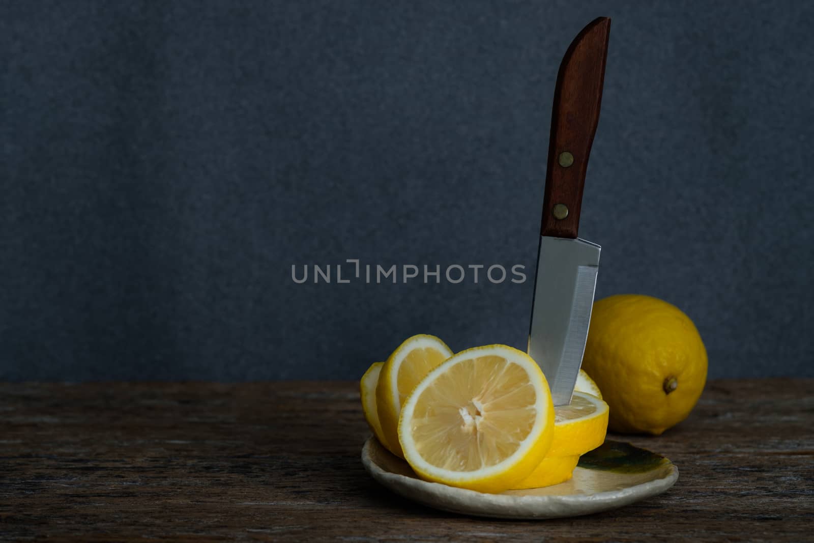 Still life with lemons on rustic low key background, Choose focal point, dark light style.