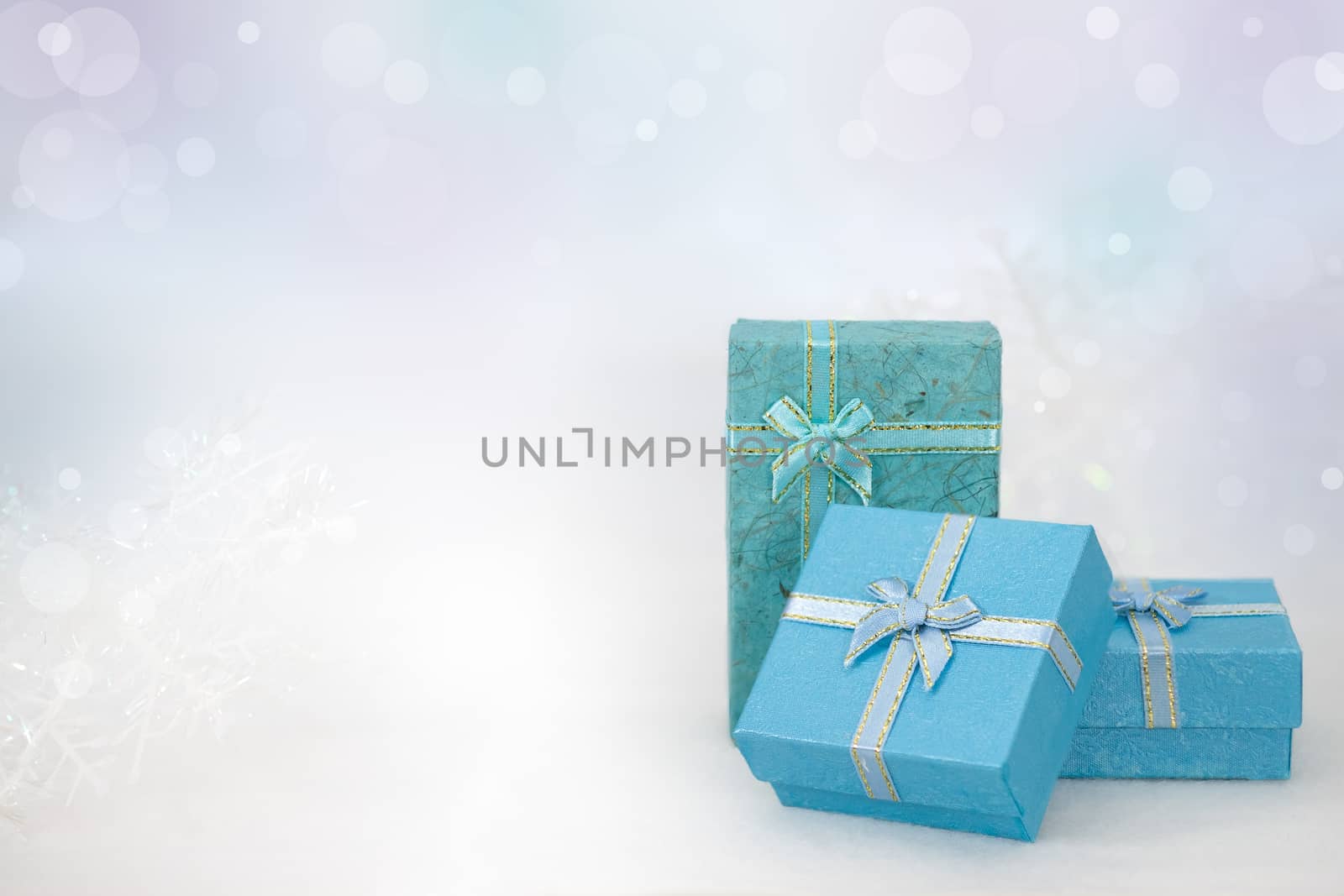 Blue gift boxes on the white fur in bokeh background, with copy space for season greeting. Merry Christmas or Happy New Year, AF point selection,blurred.