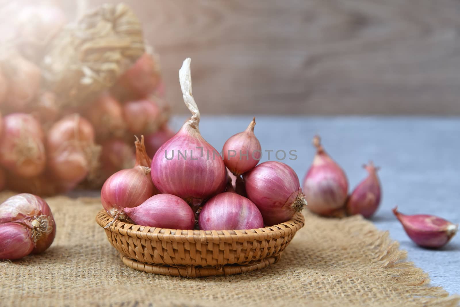 Thai red onion or Shallots. Fresh purple shallots on bamboo bask by C_Aphirak