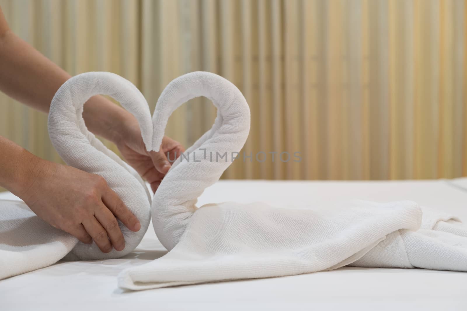 Close-up of hands putting folded swans bird of fresh white bath  by feelartfeelant