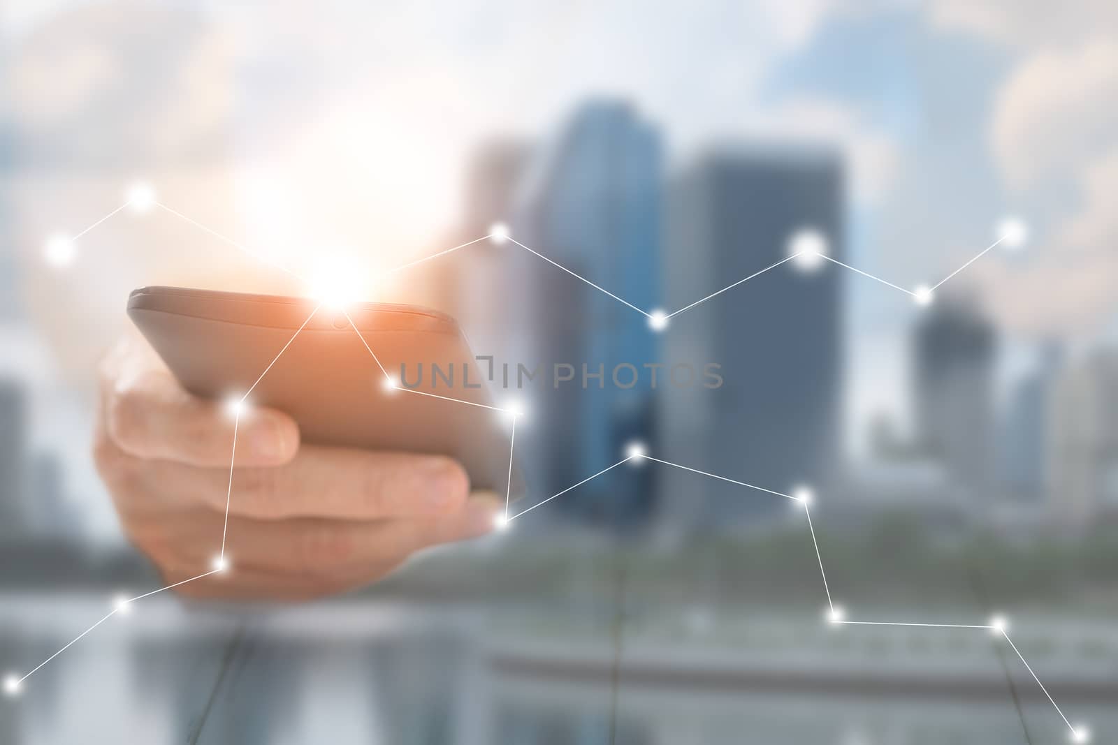 Hand of a businessman holding a smartphone. There is a network of business contacts. A concept of communication, this image focuses on blurring to be used as the background.