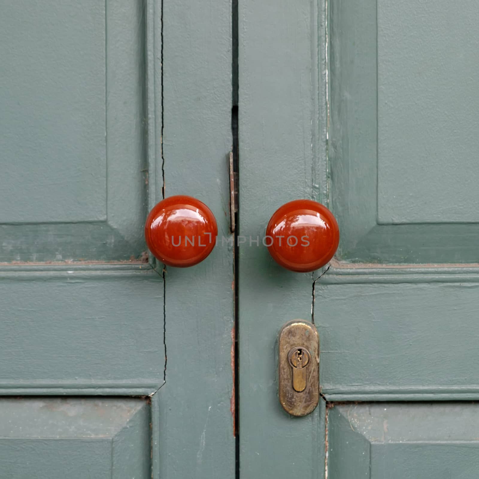 Antique red Doors locked on green door.