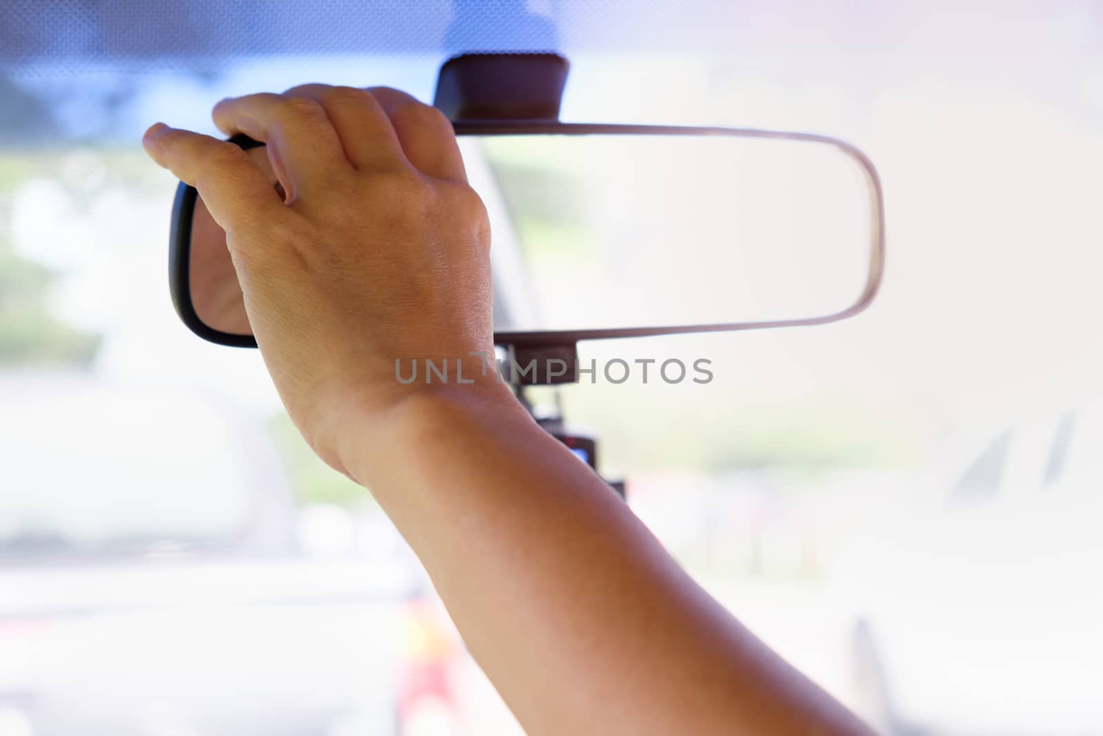 Hands are adjusting the rearview mirror for good braking and safe car