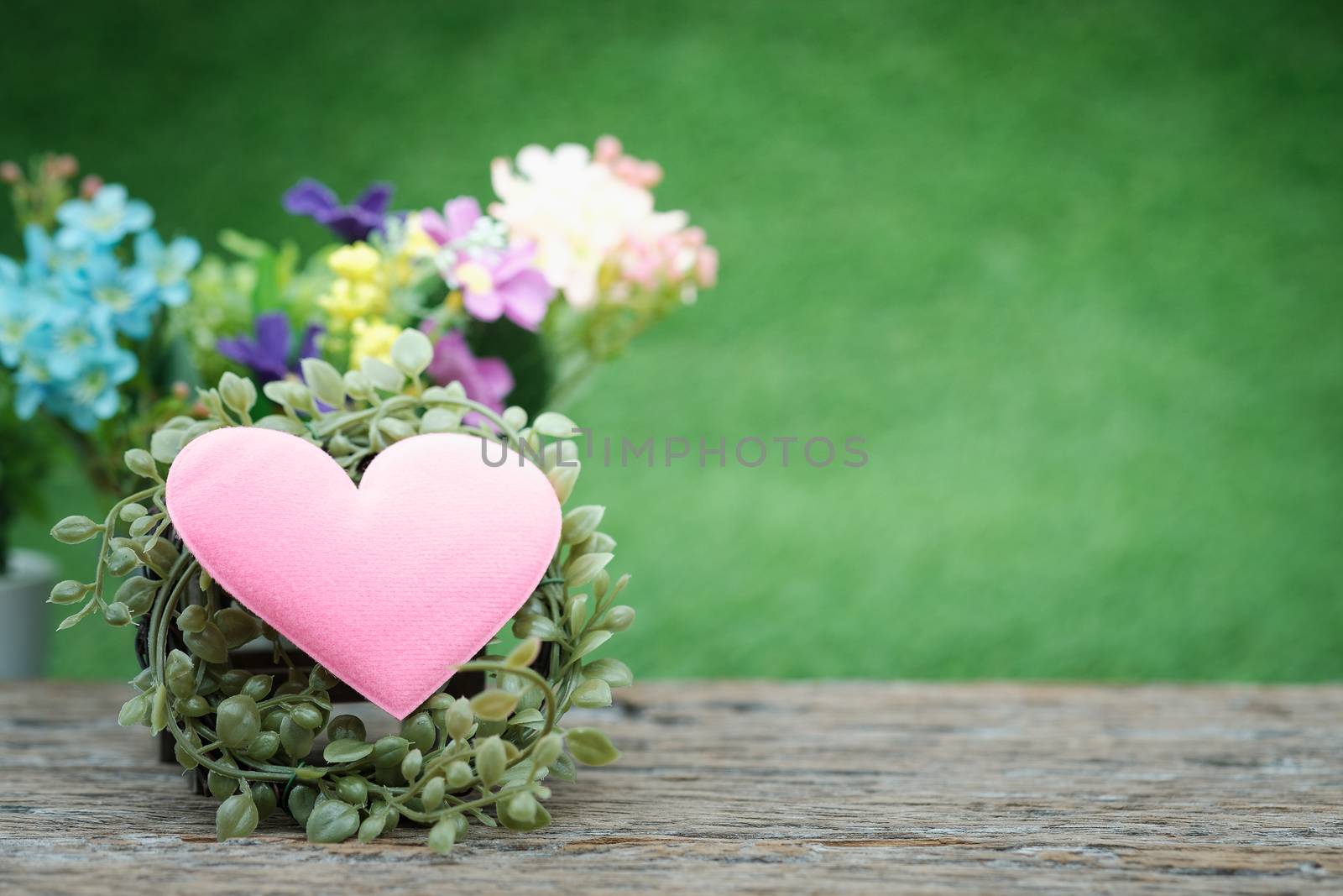 A bouquet of flowers and mini shape-heart on a wooden floor in green garden background for valentine day, AF point selection, with space for write.
