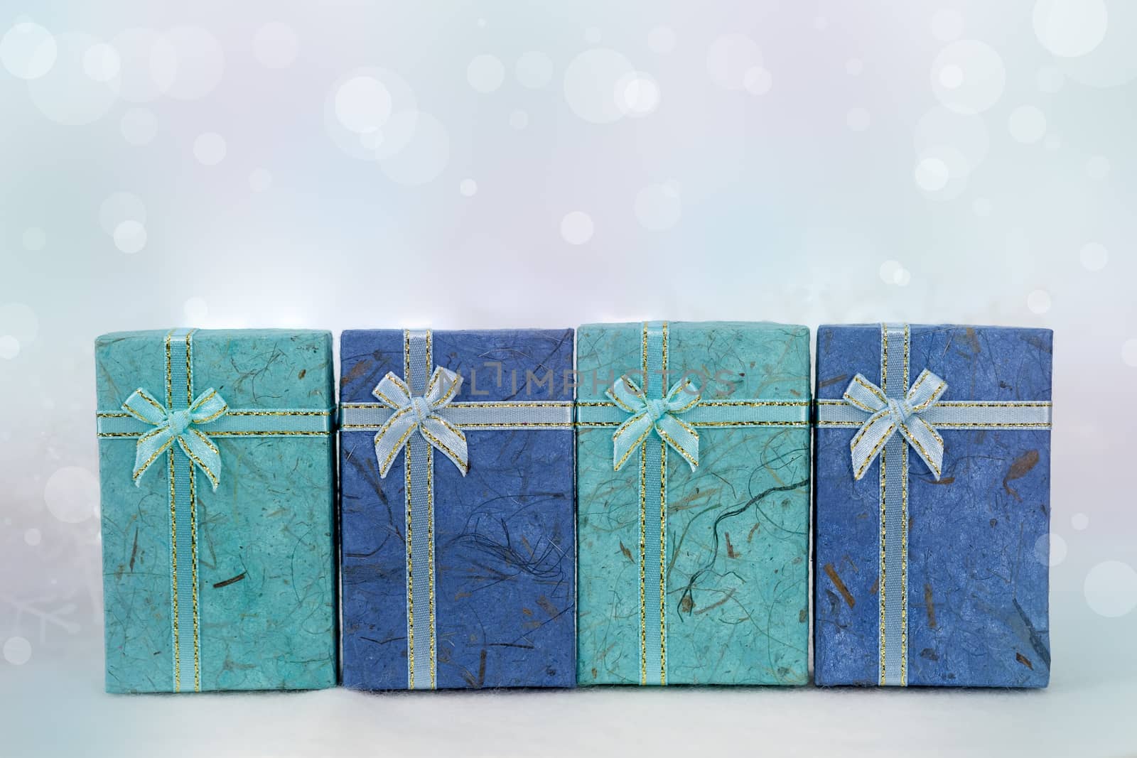 Blue gift boxes on the white fur in bokeh background, with copy space for season greeting. Merry Christmas or Happy New Year, AF point selection,blurred.