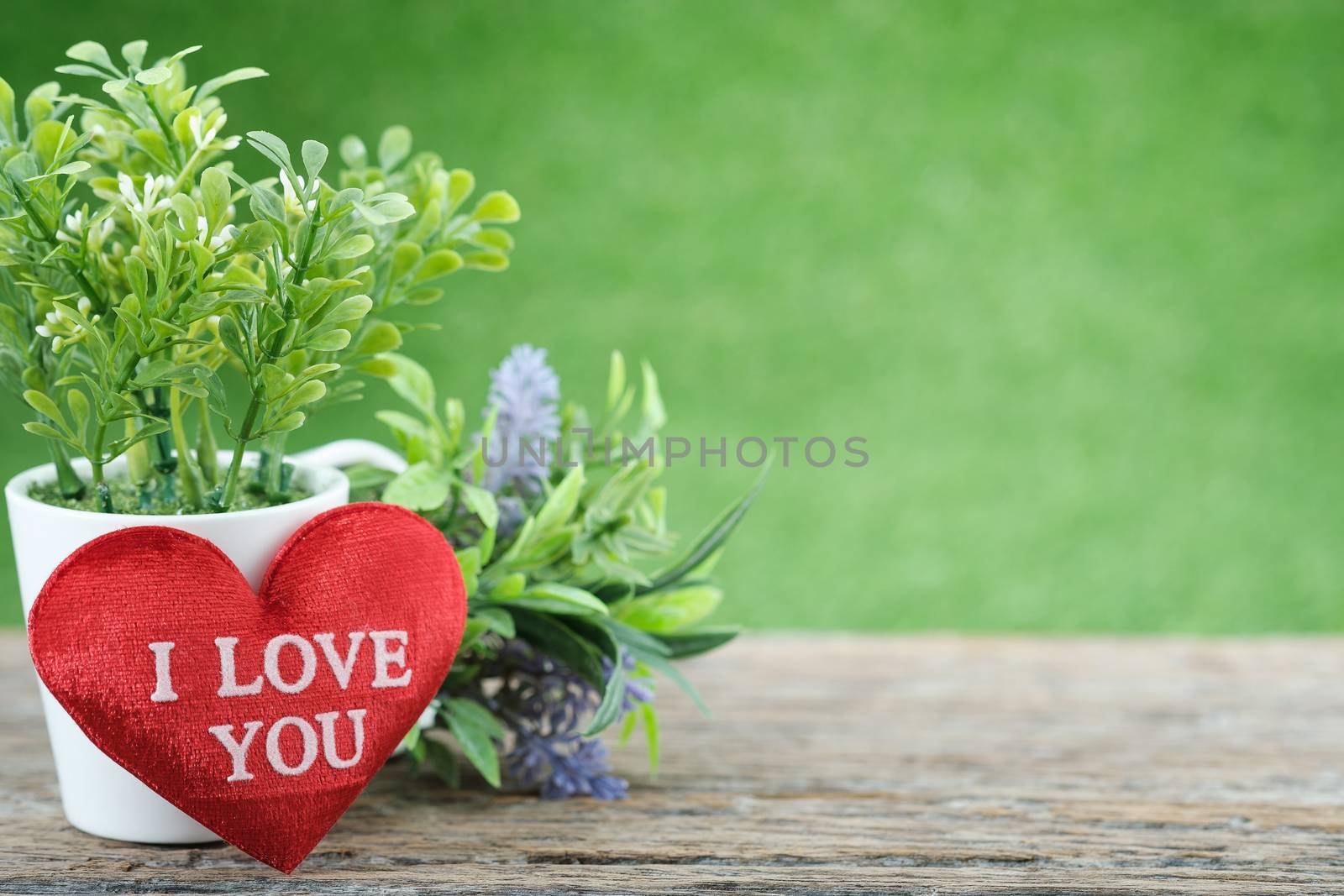 A bouquet of flowers and mini shape-heart on a wooden floor in green garden background for valentine day, AF point selection, with space for write.