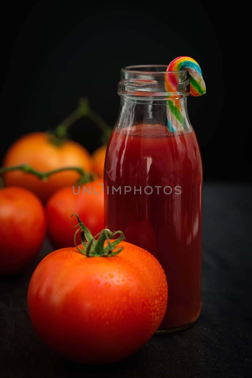 Still life of fresh ripe tomatoes juice on wooden background, Choose focus point. Good health concept.  Vertical picture style.