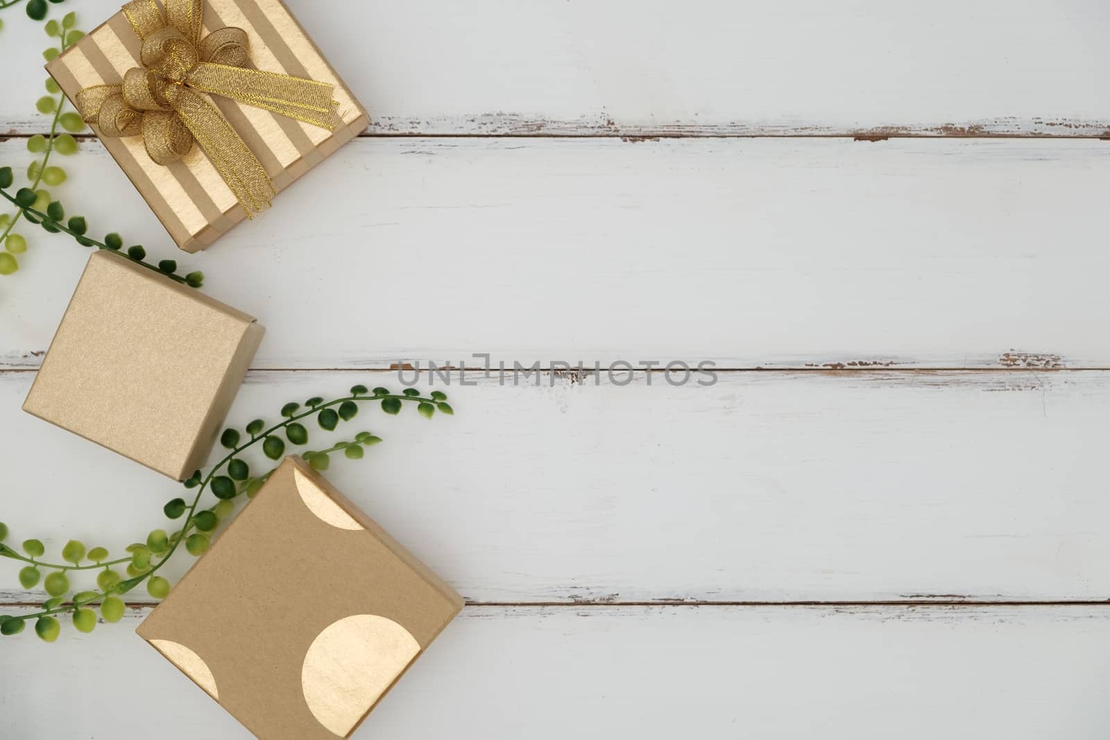 Gift box on white wooden background with green grass by feelartfeelant