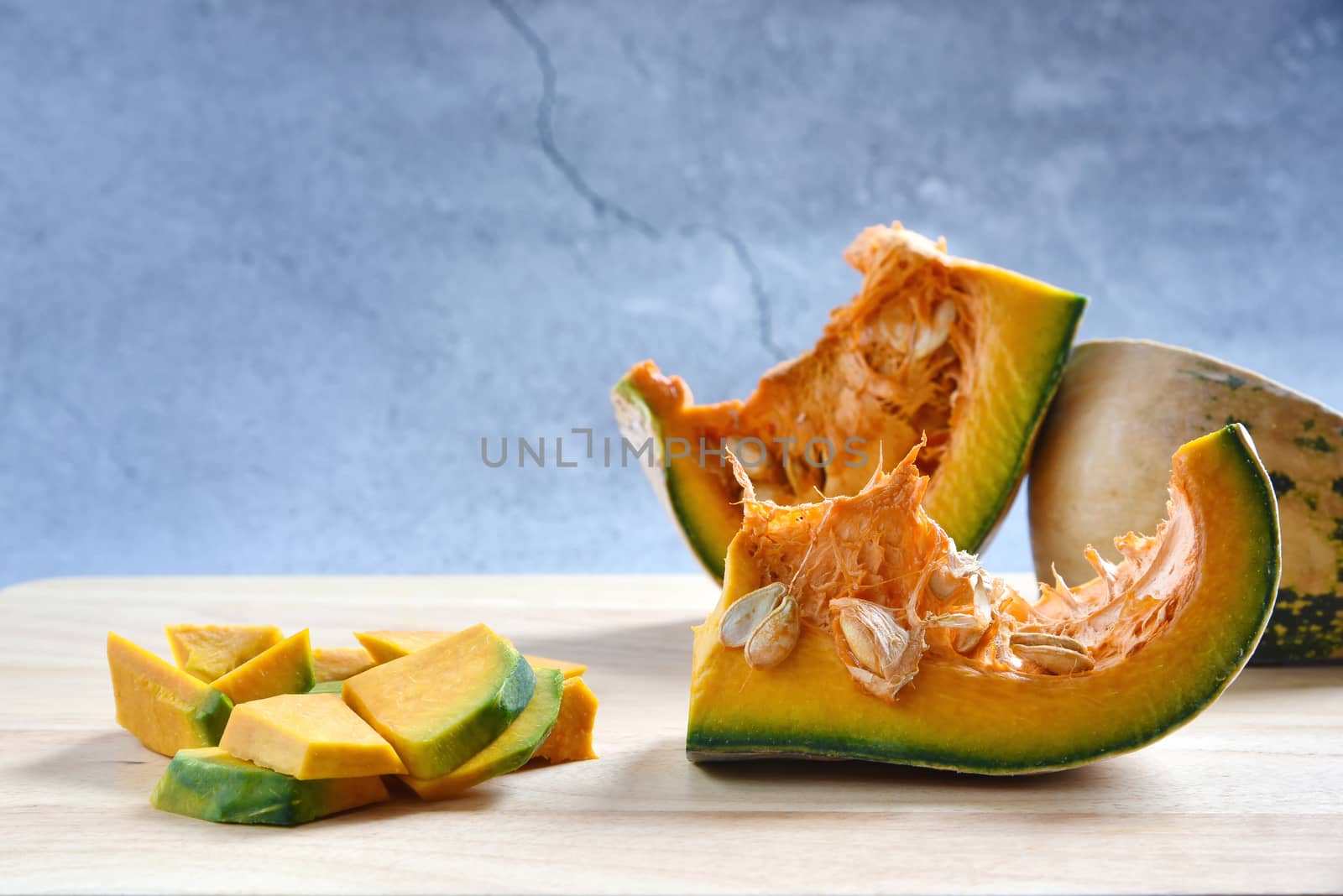 Pumpkin slices Diced and pumpkin porridge on a wooden in dark ba by C_Aphirak