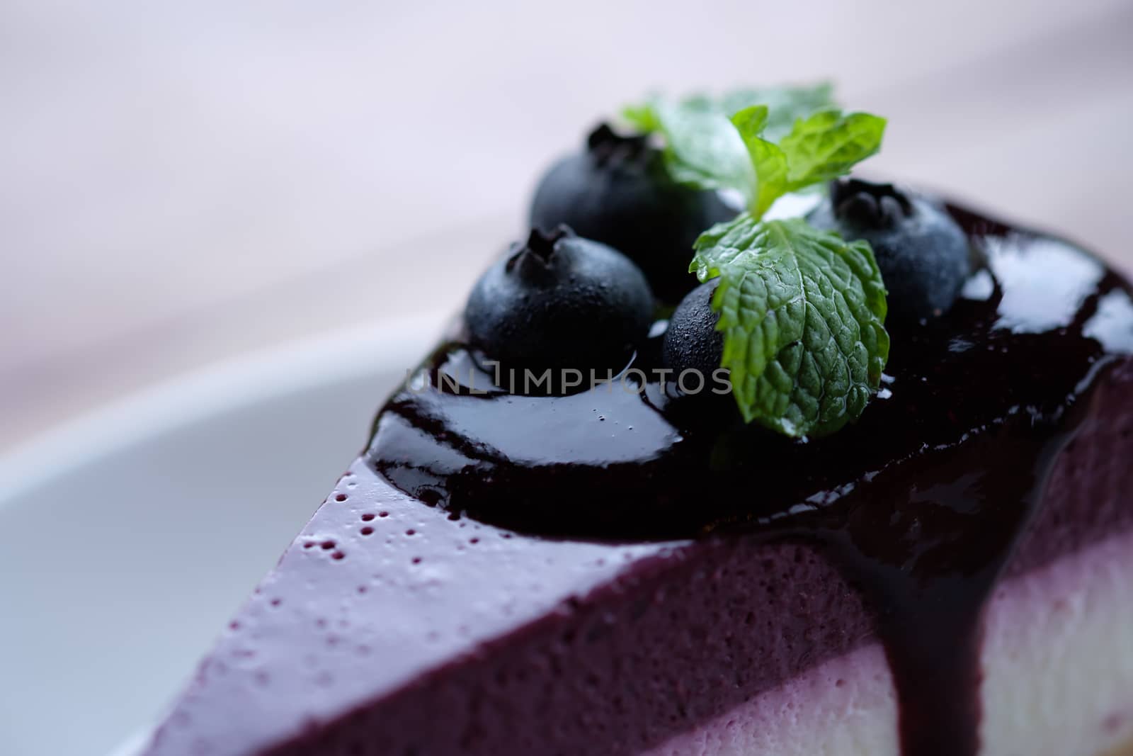 Blueberry Mousse Cake Topped with  fresh Blueberries and mint leaves.