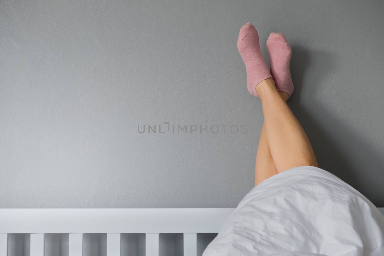 Good morning by stretching feet with pink socks out of the blank by feelartfeelant