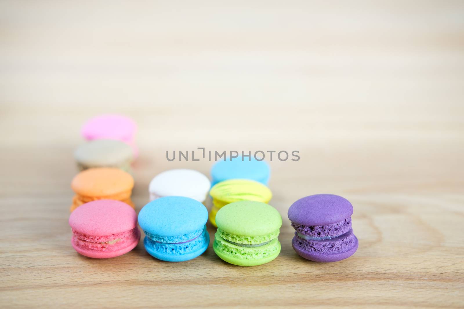 Sweet and colorful, Different kinds of macaroons in graph on light wooden background with blank space,selective focus, Dessert.