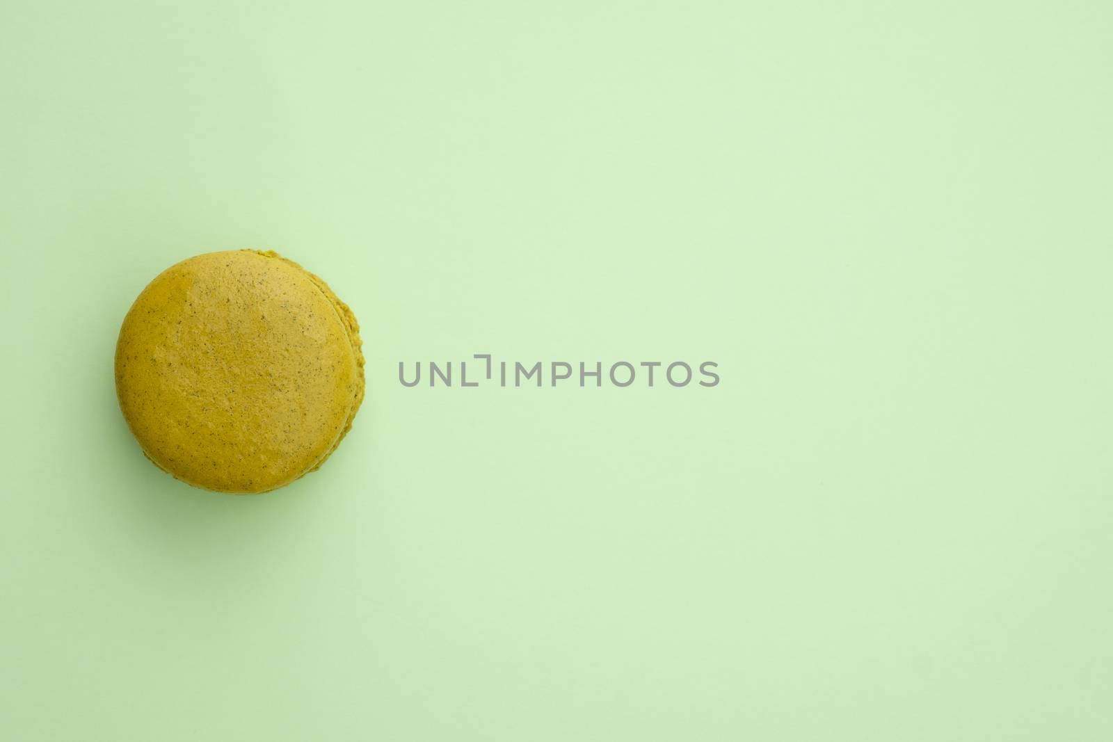 Macaroon on a green background. Top view, Space to write at right.