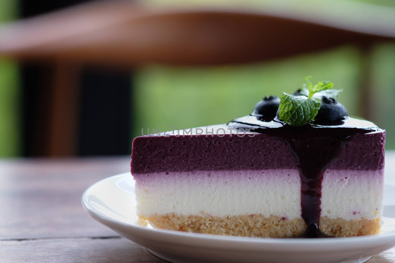Blueberry Mousse Cake Topped with  fresh Blueberries and mint leaves.