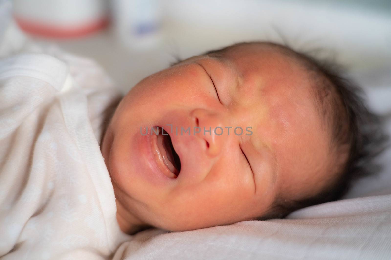 adorable cute newborn baby infant  lying on the bed and cry