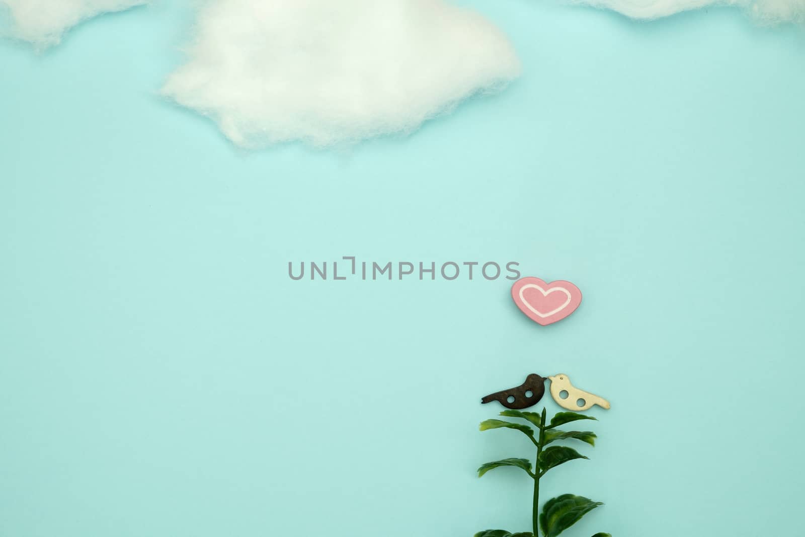 Wooden bird and a heart-shaped  on blue background with copy space for write and valentine concept.