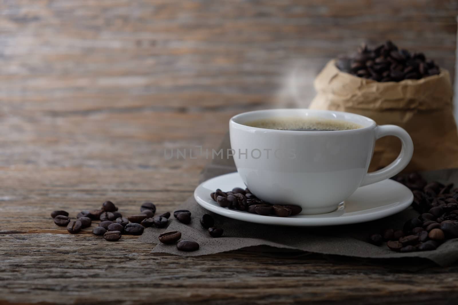 Hot Coffee cup with Coffee beans on the wooden table with copy space to write.