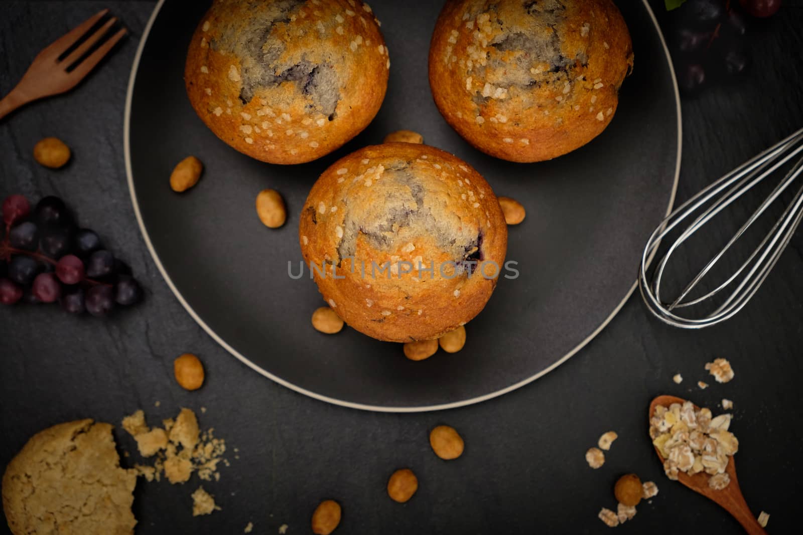 Top view of blueberries muffins on black background in a rustic style. Select the focus point.