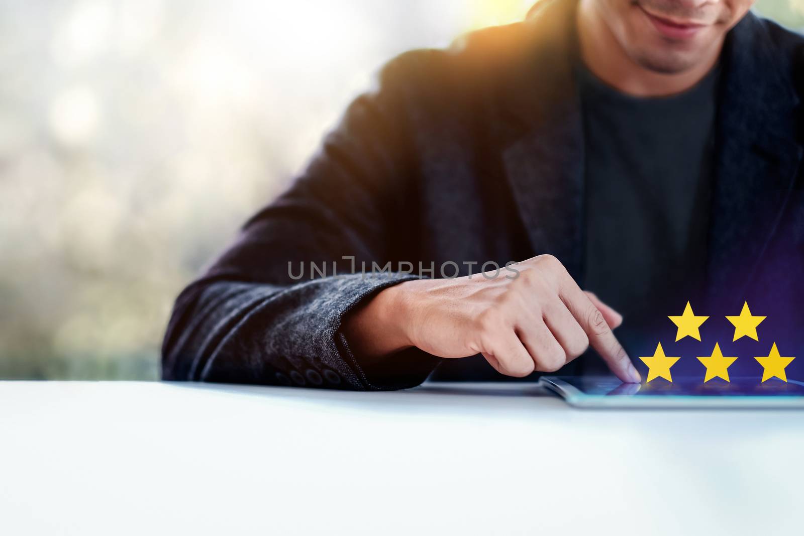 Customer Experiences Concept. a Modern Man Giving Five Stars Rating, Positive Review via Tablet. Client's Satisfaction Surveys Online. Front View. Selective Focus and Cropped image