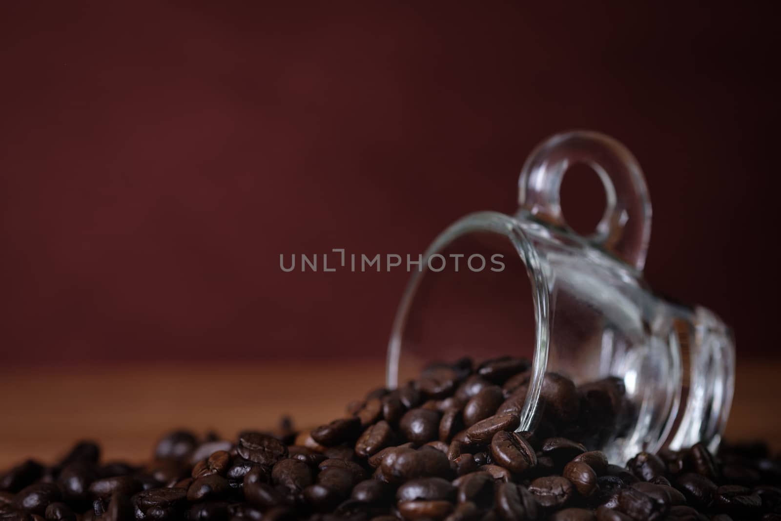 cup of coffee with roasted coffee beans 
On a wooden desk.