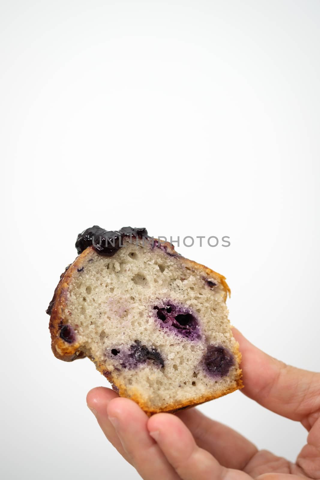 Hands holding a blueberry muffin look delicious. by feelartfeelant