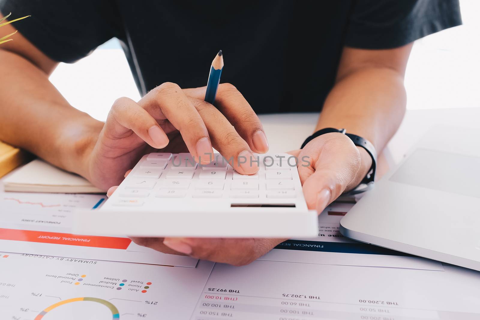 Close up Business man using calculator and laptop for do math finance on wooden desk in office and business working background, tax, accounting, statistics and analytic research concept