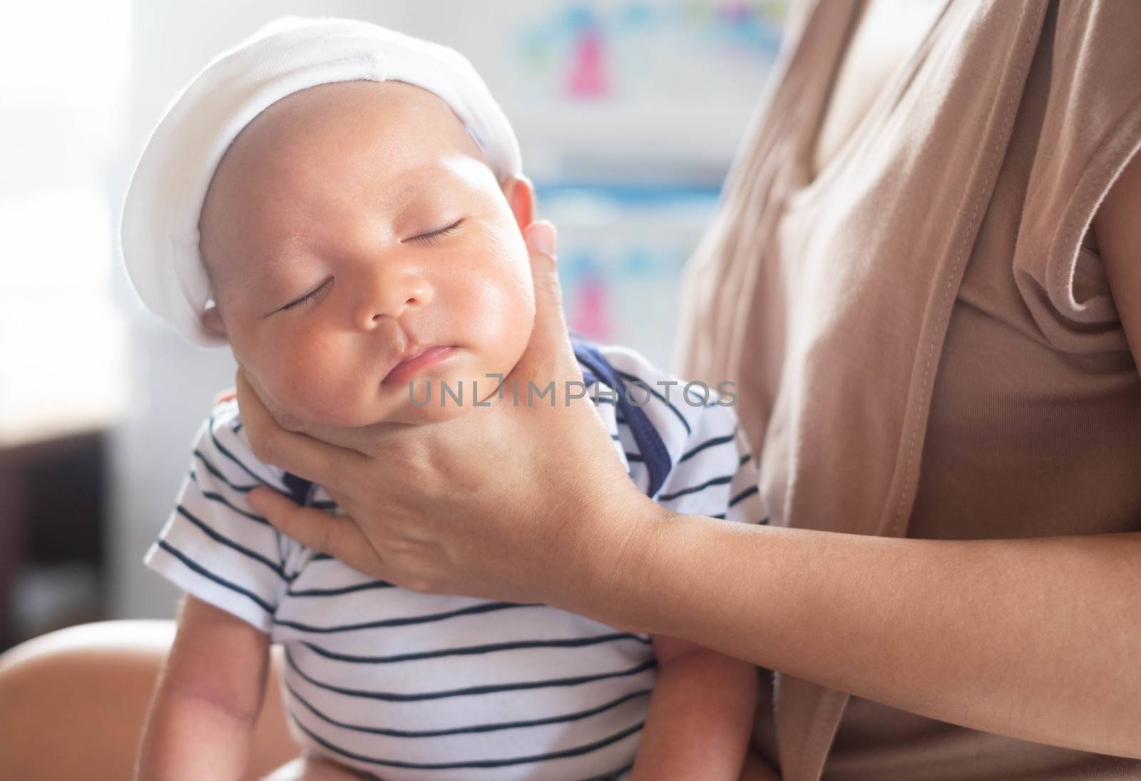 Soft focus photo of mother, mom using hand Hold baby to help a baby newborn infant belch burping after breastfeeding milk to heal gas pain or indigestion