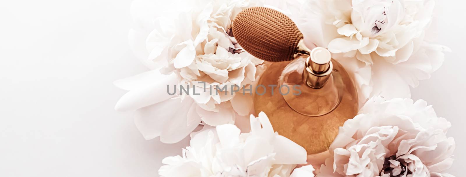 Fragrance bottle as vintage perfume product on background of peony flowers, parfum ad and beauty branding design