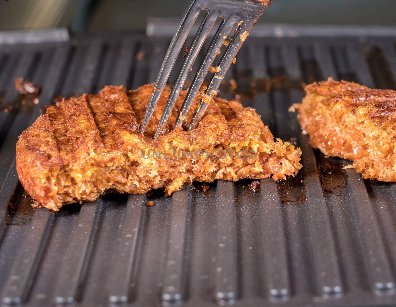 Close shot of the meat like plant-based patties for vegetarian beef burgers being grilled on hot griddle