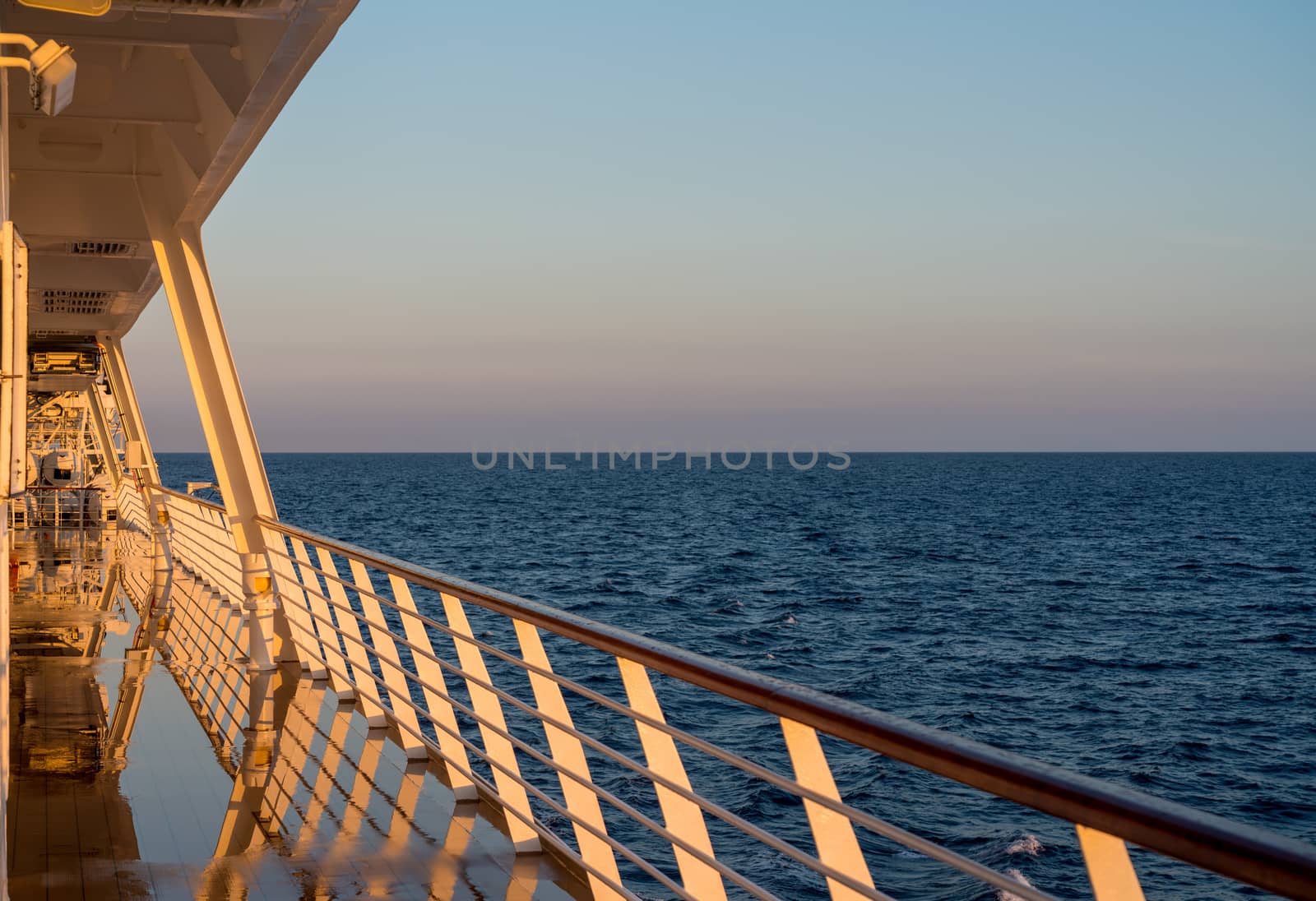 Deck on small cruise liner sailing across the ocean as the sun rises