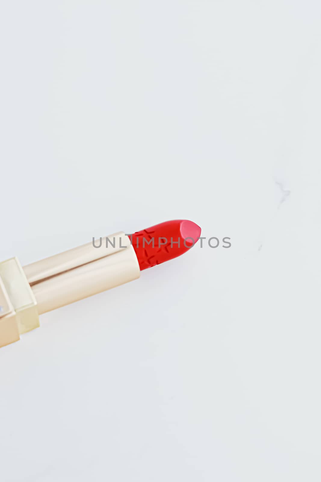 Luxury lipstick in a golden tube on white marble background, make-up and cosmetics by Anneleven