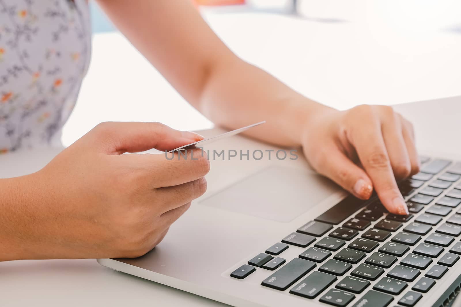 Close up hand of woman using laptop computer and holding credit card  by nateemee