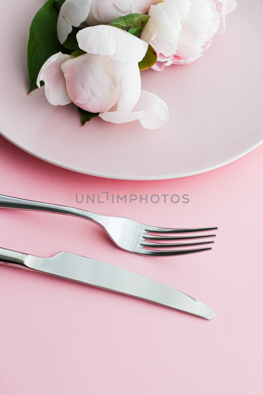 Dining plate and cutlery with peony flowers as wedding decor set on pink background, top tableware for event decoration and menu branding by Anneleven