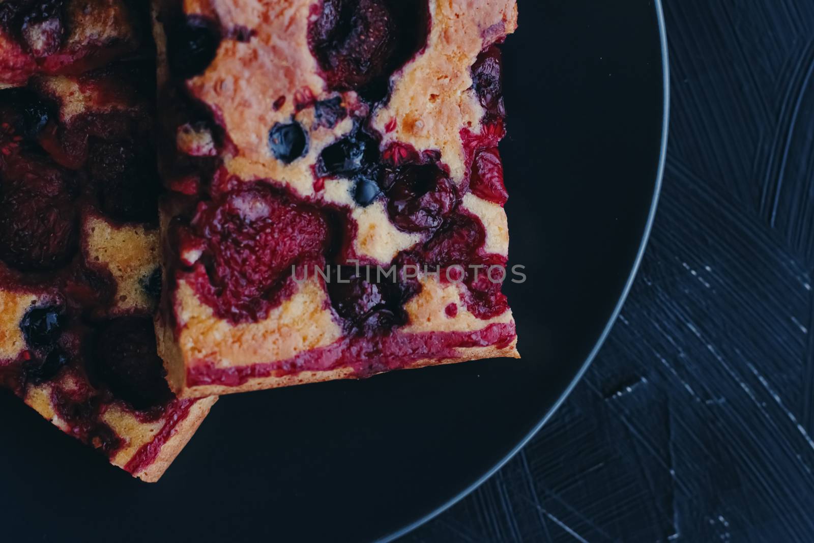 Berry pie on black plate, rustic homemade food with organic ingredients by Anneleven