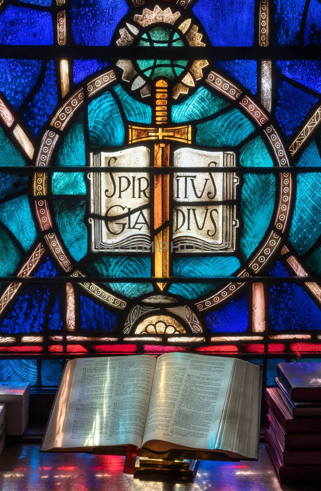 Light from stained glass window falls on open bible in american church by steheap