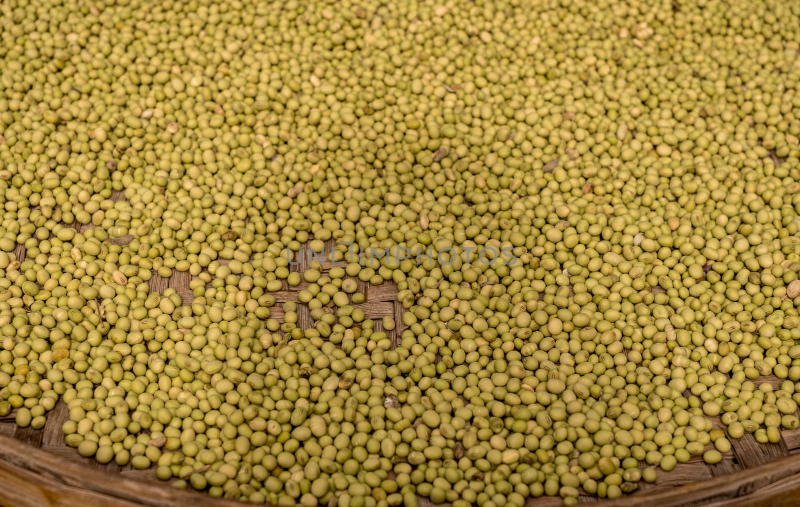 Large basket of green split peas drying inside Tulou in Fujian Province in China