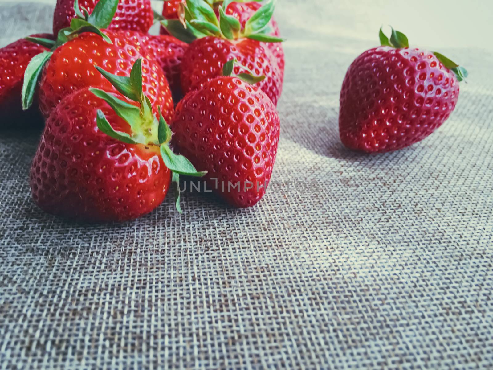 Organic strawberries on rustic linen background by Anneleven