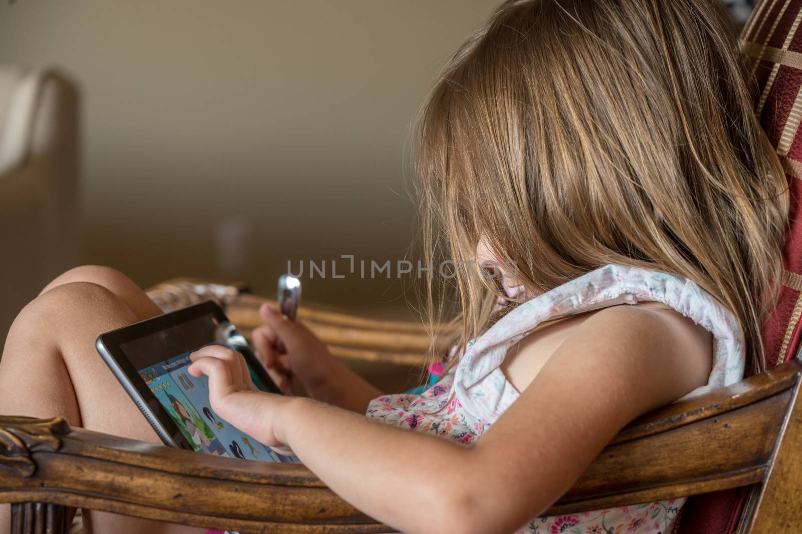 Young preschooler playing with a modern electronic tablet by steheap